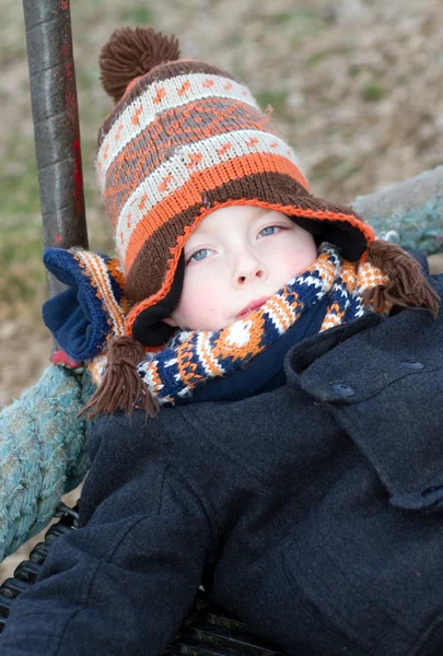 Happy young boy playing at the park on a cold day — Stock Photo, Image