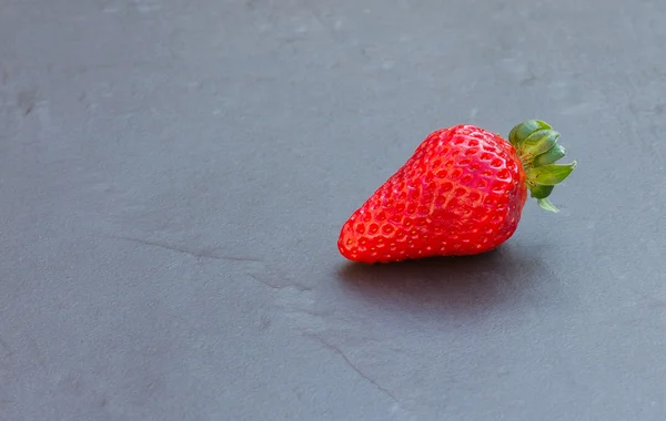 Aardbei op een zwarte leisteen tegel — Stockfoto