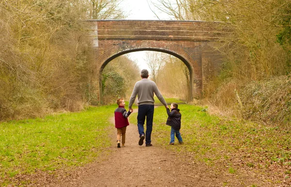 Children walking with their father — Stock Photo, Image