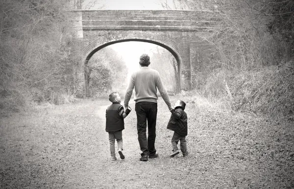 그들의 아버지와 함께 걷는 아이 들 스톡 이미지