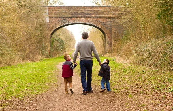 그들의 아버지와 함께 걷는 아이 들 스톡 사진