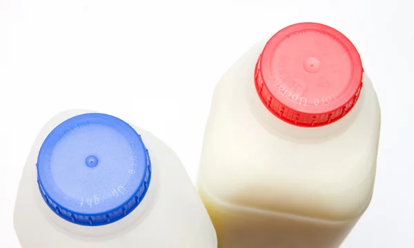 Magere en volledige magere melk in containers — Stockfoto
