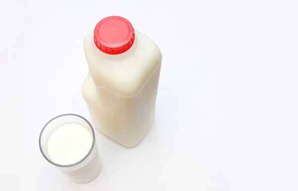 Glass of milk with carton behind — Stock Photo, Image