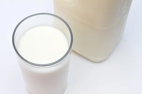 Vetro di latte con cartone dietro — Foto Stock