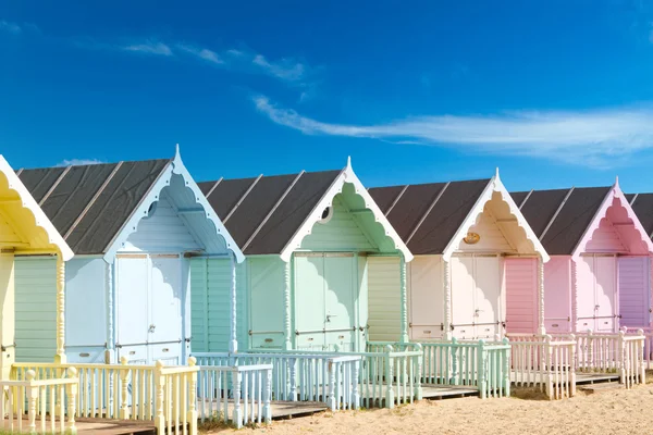 Traditional British beach huts on a bright sunny day Stock Image