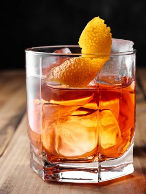 Bir bardak kayanın içinde Negroni kokteyli. Dikey fotoğrafçılık.