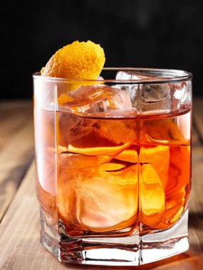 Bir bardak kayanın içinde Negroni kokteyli. Dikey fotoğrafçılık.