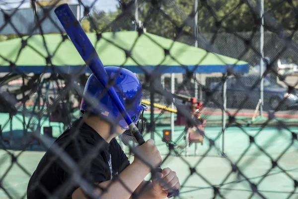 Een tiener jongen op een batting cage — Stockfoto