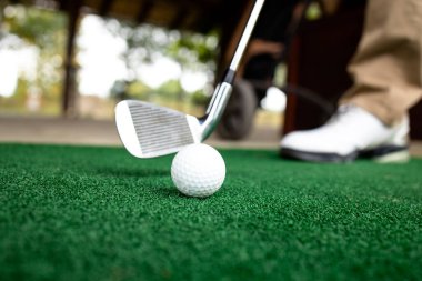 Golfçü golf sahasında topa vurmaya hazırlanıyor..