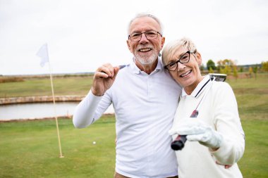 Golf sopalarıyla en sevdikleri sporu yapan ve eğlenen emekli yaşlıların portresi..