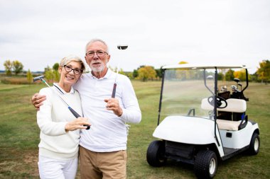 Golf sahasında golf sopaları olan Kafkas golfçülerin portresi..