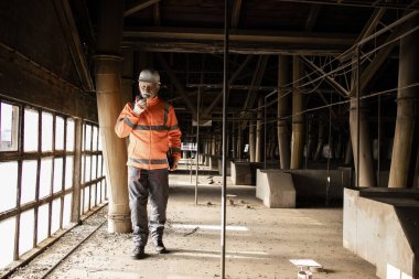 Fabrika koridorunda duran sanayi işçisi.