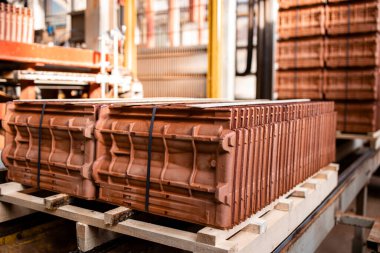 Fabrika ürünleri paketlenmeye hazır. Çatı kiremitleri ve inşaat malzemeleri fabrikası üretimi. Sanayi için kaliteli çatı kiremitleri taşıyan otomatikleştirilmiş endüstriyel makine.