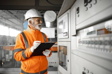 Güvenlik ekipmanları sanayi mühendisi. Üretim salonundaki elektrik tüketimini kontrol ediyor..