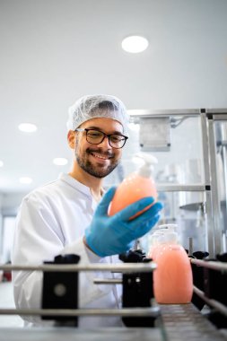 Kimya endüstrisinde çalışan teknoloji uzmanı fabrikada sıvı sabun kalitesini ve üretimini kontrol ediyor..