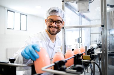 Kimyasal endüstrisinde sıvı sabun veya deterjan kalitesini kontrol eden üretim hattı taşıma makinesinde çalışan bir fabrika teknoloji uzmanı..