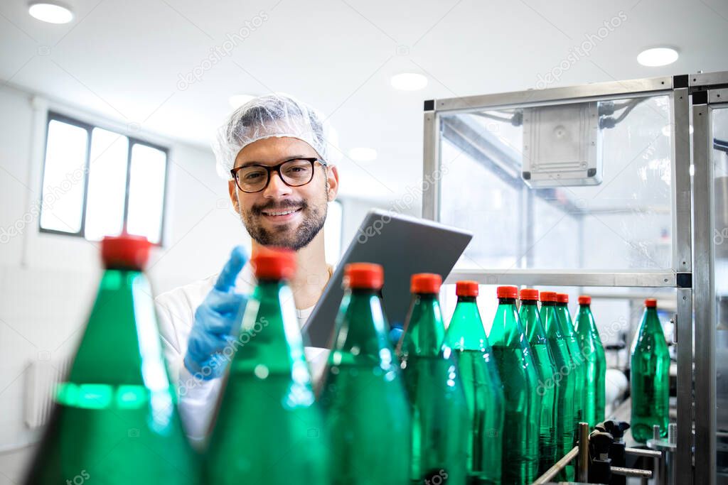 Working in bottling water factory and production line worker checking quality of beverage and plastic packaging.