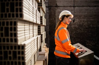 Kil tuğla fabrikasında çalışan fabrika işçisi inşaat endüstrisi için ürün üretiyor..