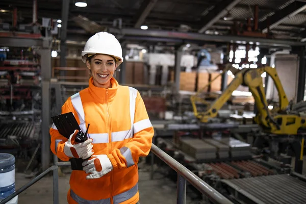 Portrait of female supervisor checking production line in manufacturing factory.