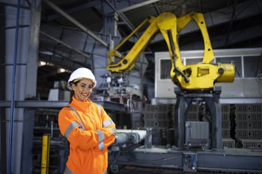 Güvenlik yeleği giyen ve imalat fabrikasında çalışan yeni ürünler geliştiren güzel kadın mühendisin portresi..
