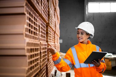 Kadın fabrika işçisi yeni ürünlerin envanterini ve kalitesini kontrol ediyor..