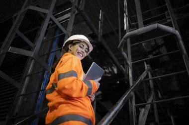 Gaz ve petrol platformunda duran güvenlik ekipmanları içinde kadın rafineri işçisi. Enerji ve gaz üretimi.