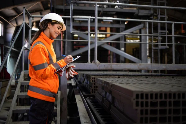 建設業のための建物レンガの品質をチェックする女性工場労働者 — ストック写真