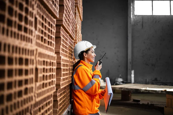 Koruyucu ekipman sanayi işçisi ve radyo iletişimi ile üretimi kontrol eden sabit şapka..