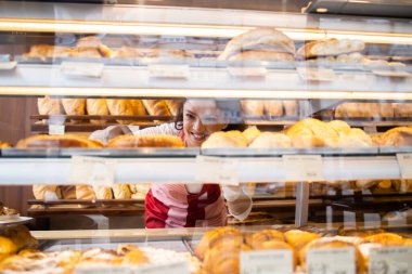 Pastanede çalışmak ve raflardaki lezzetli pastaları düzenlemek. Taze pişmiş simit ve ekmek satıyorum..
