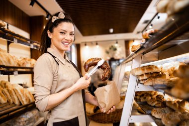Şarküteri işçisinin portresi taze hamur işleri satıyor ve süpermarkette yetişiyor..