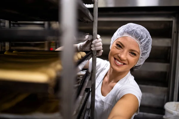 白いきれいな制服を着た女性パン屋の肖像とパン屋の生産にパンを準備するヘアネット — ストック写真