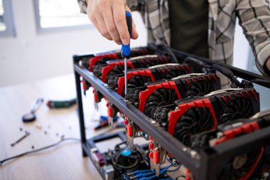 Tanımlanamayan kişi ya da bitcoin kripto para birimi için yeni bir maden donanımı inşa eden bir uzman. Engelleme teknolojisi ve grafik kartları satırda.