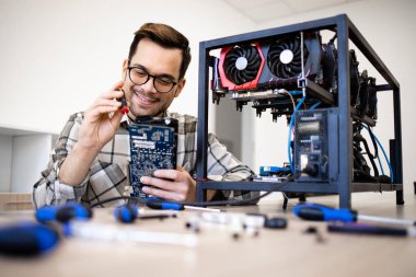 Bitcoin uzmanı kripto para madencilik donanımı kuruyor ve grafik kartı soğutma vantilatörlerini kontrol ediyor.