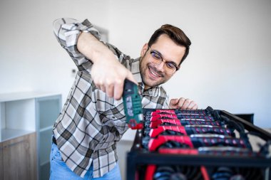 Akıllı bir beyaz adam kriptocyrrency bitcoin donanımı yapmak için tornavida kullanıyor..