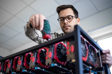 Akıllı bir beyaz adam kriptocyrrency bitcoin donanımı yapmak için tornavida kullanıyor..