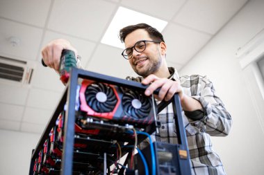 Akıllı bir beyaz adam kriptocyrrency bitcoin donanımı yapmak için tornavida kullanıyor..