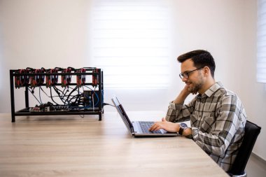 Programcısı kripto para madencilik platformu üzerinde çalışıyor bitcoin değeri ve kazançlarını kontrol ediyor.