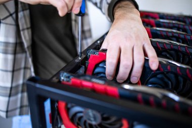 Tanımlanamayan kişi ya da bitcoin kripto para birimi için yeni bir maden donanımı inşa eden bir uzman. Engelleme teknolojisi ve grafik kartları satırda.