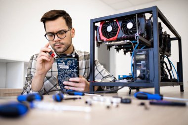 Bitcoin madenci uzmanı yeni kripto para birimi donanımı kuruyor ve madencilik için grafik kartını kontrol ediyor.