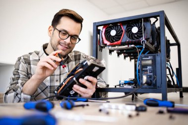 Beyaz adam grafik kartını koruyor ve bitcoin madencilik donanımı kuruyor..