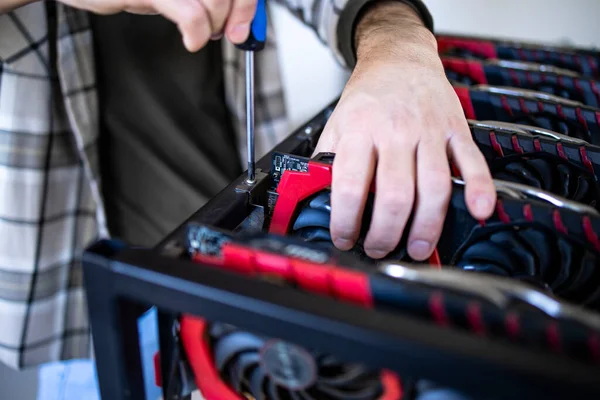 Tanımlanamayan kişi ya da bitcoin kripto para birimi için yeni bir maden donanımı inşa eden bir uzman. Engelleme teknolojisi ve grafik kartları satırda.