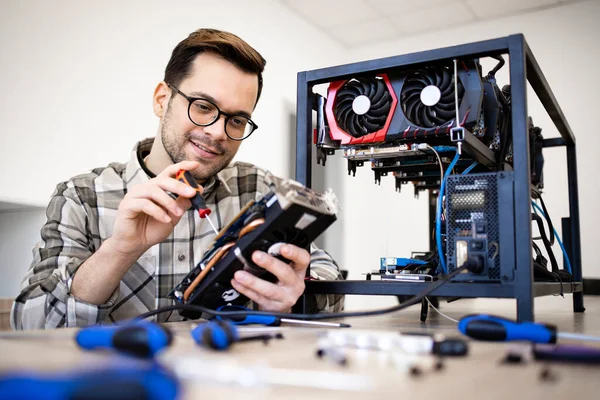 Beyaz adam grafik kartını koruyor ve bitcoin madencilik donanımı kuruyor..