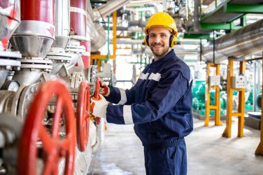 Isıtma tesisi, gaz ve sıcak su boru hattı ve beyaz fabrika işçisi vanayı kapatıyor..