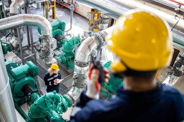 Rafineride petrol ve gaz üretimini kontrol eden endüstri denetçisi veya mühendisi.