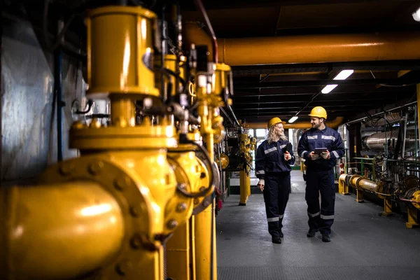 Παραγωγή Διυλιστηρίων Πετρελαίου Και Αερίου Εργάτες Εξοπλισμό Ασφαλείας Περπατώντας Σωλήνες — Φωτογραφία Αρχείου