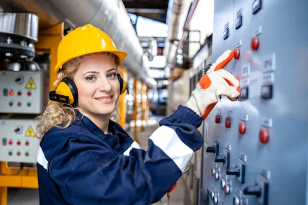 Portrait of female industrial electrician checking voltage and installations in power plant.