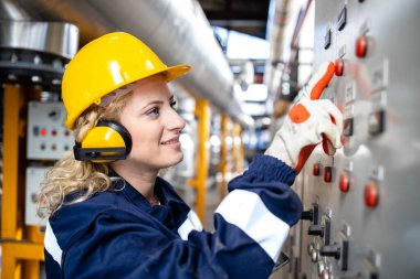 Elektrik santralindeki voltaj ve tesisleri kontrol eden kadın fabrika elektrikçisinin portresi.