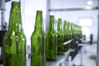 Bira fabrikası ve cam şişeler taşıyıcıda..