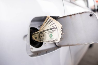 Benzin fiyatları krizi konsepti ve benzin deposunda dolar.