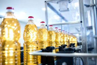 Gıda üretim tesisinde otomatikleştirilmiş konveyör üzerinde şişe bitkisel yağ üretiliyor.